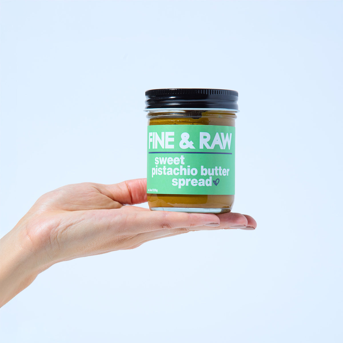 Jar of Sweet Pistachio Spread by FINE & RAW organic bean to bar chocolate, styled product photo