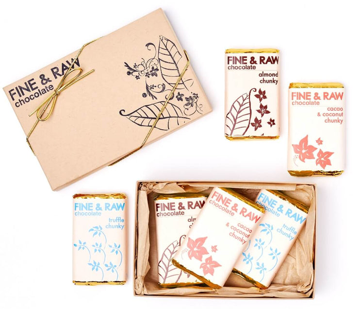 Six hand-wrapped Fine & Raw Chunky chocolate bars arranged in a box with a leaf-and-flower themed design.